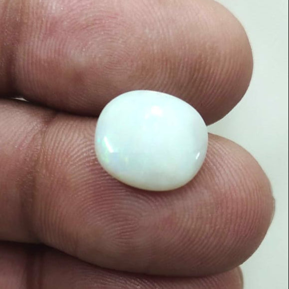 White object held between fingers against a blurred background